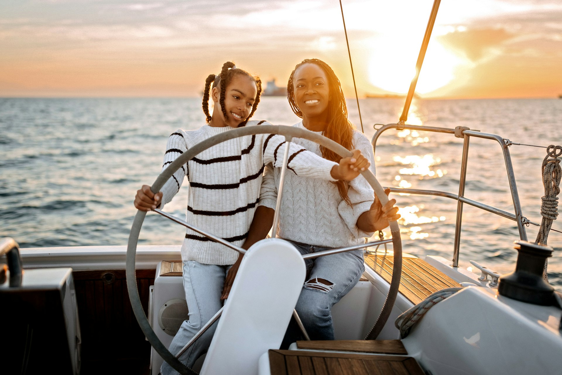 Mother and daughter sailing together in Greece as the sunsets in the background
