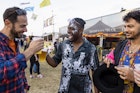 Group of mixed age and ethnic male friends having fun at a festival in Northumberland, North East England. They are laughing and drinking beer together, toasting their pints.
1457658884