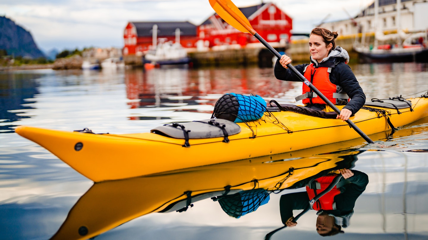 1492760985
A woman kayaking under the Midnight Sun in Lofoten Islands, Norway