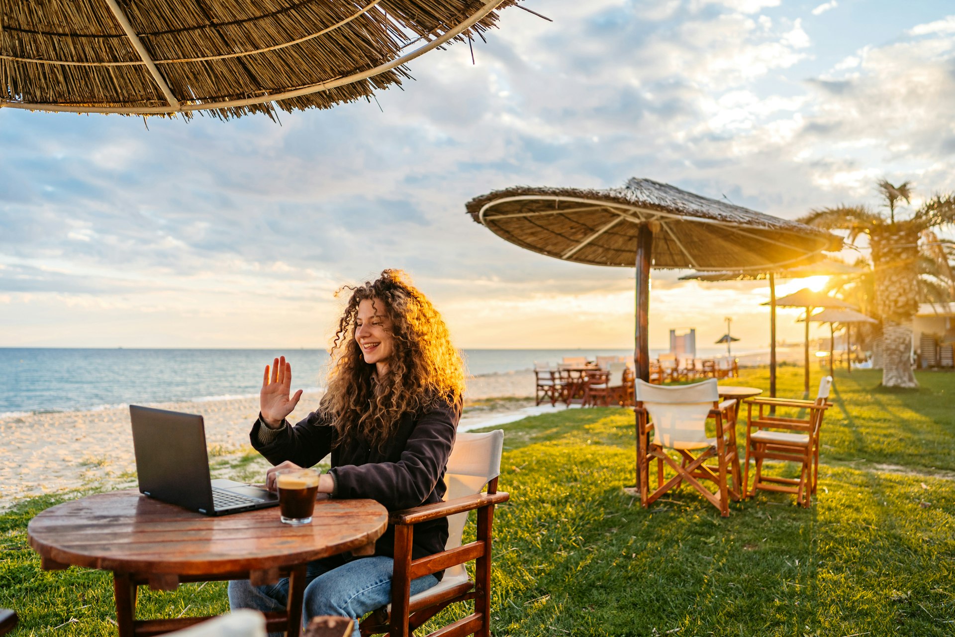 Hermosa joven trabajando en una laptop en un bar de playa en Nea Flogita, Grecia. 