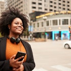 Immersed in the urban rhythm, a woman in a suit and headphones stands in downtown Chicago, awaiting her carpool with poised anticipation.
1498638733
A woman smiling on the side of the street in Chicago