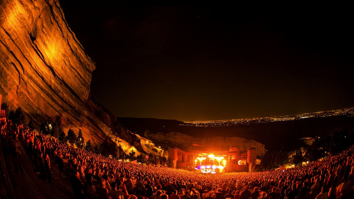 Crowd watches band play with a scenic view of the surroundings.
