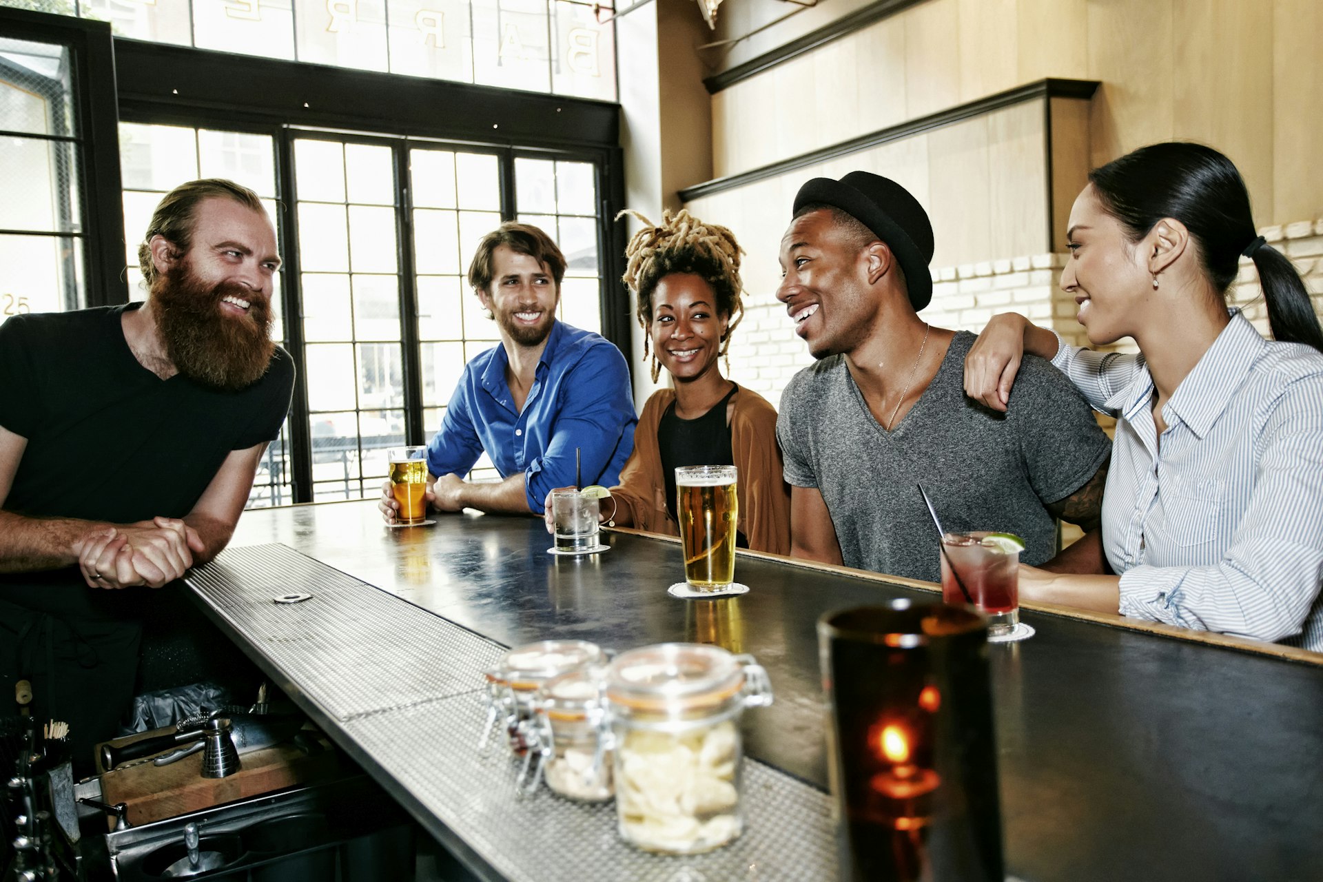 A group of friends smiling and laughing with the bartender