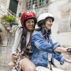 ""
699091621
20 to 24 years, 25 to 29 years, bonding, casual clothing, caucasian ethnicity, crash helmet, croatia, dalmatia, day, denim jacket, dress, feminine, friendship, getting away from it all, happiness, health-and-safety, leisure, lifestyle, moped, on the go, on the road, only female, only young women, outdoors, riding, road trip, sharing, side view, split croatia, summer, three quarter length, togetherness, tourist, traditional, transport, travel destination, two people, village, wearing, young adult, young woman, Split, Dalmatia, Croatia
Two women riding a moped around Split in Croatia