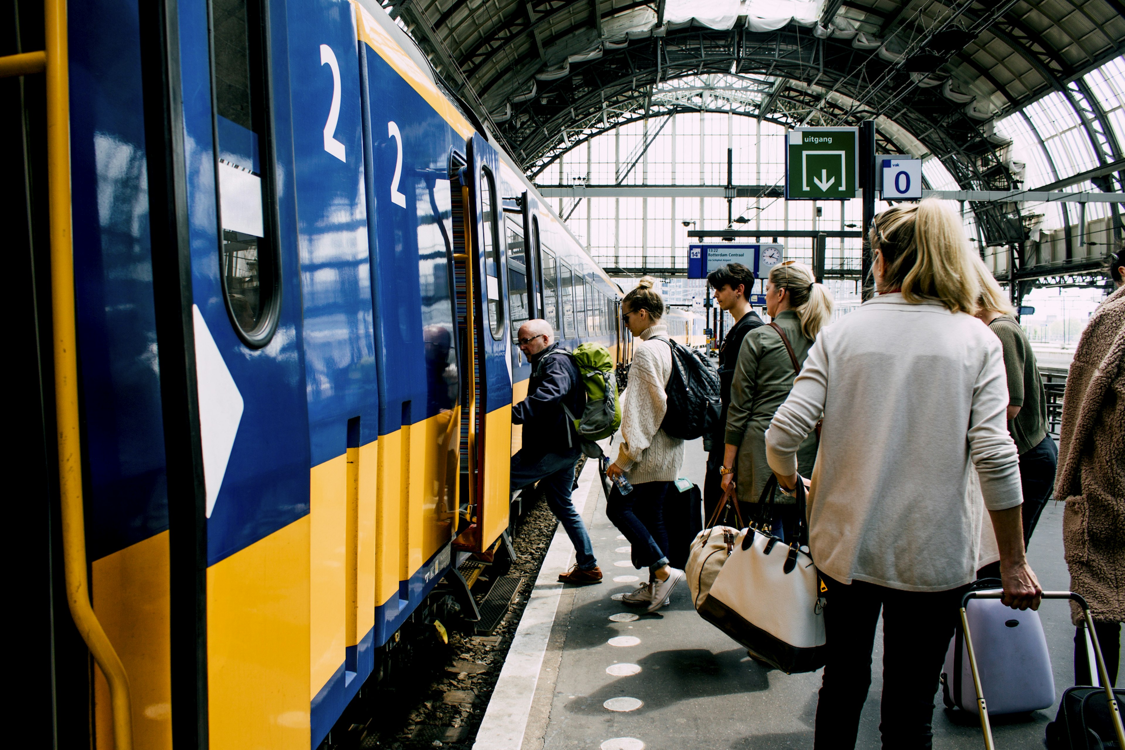 People with luggage boarding a train