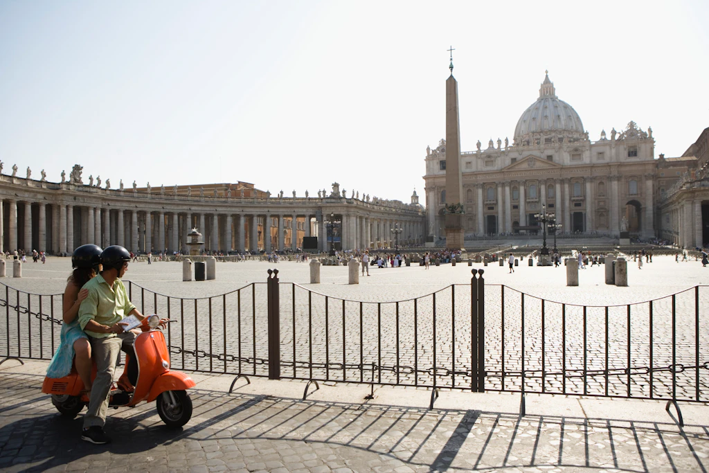 St Peter's Basilica in Rome A couple on a scooter looking over at St Peter's Basilica and the piazza outside it