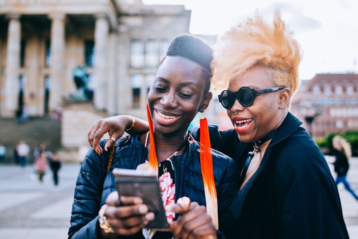 Happy friends using mobile phone in Berlin City.
957556544
Two black women laughing together while looking at a phone in Berlin