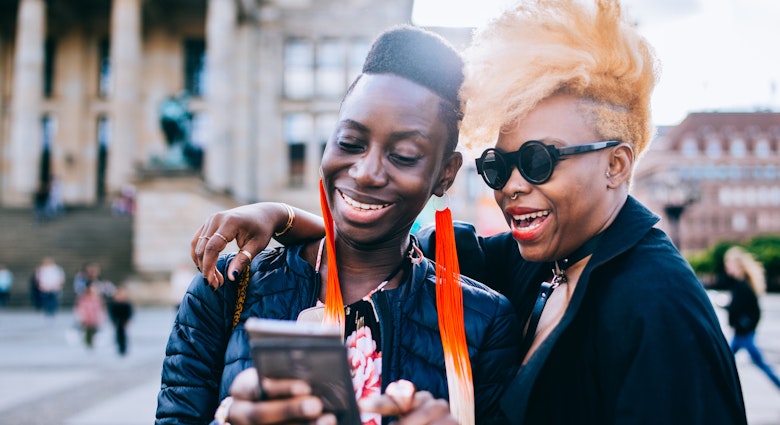 Happy friends using mobile phone in Berlin City.
957556544
Two black women laughing together while looking at a phone in Berlin