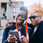 Happy friends using mobile phone in Berlin City.
957556544
Two black women laughing together while looking at a phone in Berlin