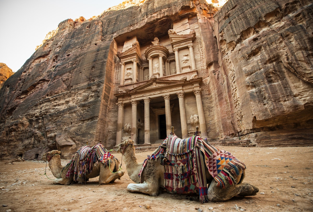 Bedouin camels resting near the treasury of Al Khazneh in Petra.
1085537554
Jordan, Entrance, Construction Industry, Jordan - Middle East, M, Mountain, Nature, Animal, Tourist, Arabic Style, Outdoors, Religion, Ravine, Monastery, Arabia, Cultures, Petra, UNESCO, UNESCO World Heritage Site, Wealth, Architecture, Petra - Jordan, Ancient Civilization, Built Structure, The Siq, Arts Culture and Entertainment, Camel, Travel, Exploration, Palace Tomb, Facade, Canyon, Adventure, Famous Place, Midsection, Transportation, Photography, Old, No People, Color Image, Travel Destinations, Horizontal, Cliff, Ancient, Contemplation, Tomb, Tourism, Stone Material, Bedouin, Sand, Khaznet, Sandstone, Treasury