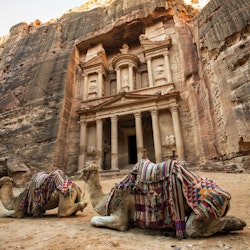 Bedouin camels resting near the treasury of Al Khazneh in Petra.
1085537554
Jordan, Entrance, Construction Industry, Jordan - Middle East, M, Mountain, Nature, Animal, Tourist, Arabic Style, Outdoors, Religion, Ravine, Monastery, Arabia, Cultures, Petra, UNESCO, UNESCO World Heritage Site, Wealth, Architecture, Petra - Jordan, Ancient Civilization, Built Structure, The Siq, Arts Culture and Entertainment, Camel, Travel, Exploration, Palace Tomb, Facade, Canyon, Adventure, Famous Place, Midsection, Transportation, Photography, Old, No People, Color Image, Travel Destinations, Horizontal, Cliff, Ancient, Contemplation, Tomb, Tourism, Stone Material, Bedouin, Sand, Khaznet, Sandstone, Treasury