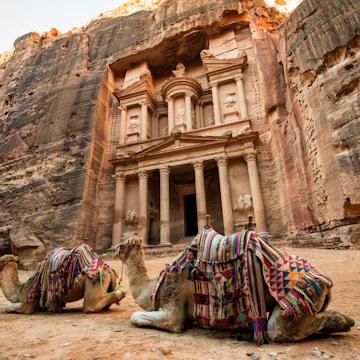 Bedouin camels resting near the treasury of Al Khazneh in Petra.
1085537554
Jordan, Entrance, Construction Industry, Jordan - Middle East, M, Mountain, Nature, Animal, Tourist, Arabic Style, Outdoors, Religion, Ravine, Monastery, Arabia, Cultures, Petra, UNESCO, UNESCO World Heritage Site, Wealth, Architecture, Petra - Jordan, Ancient Civilization, Built Structure, The Siq, Arts Culture and Entertainment, Camel, Travel, Exploration, Palace Tomb, Facade, Canyon, Adventure, Famous Place, Midsection, Transportation, Photography, Old, No People, Color Image, Travel Destinations, Horizontal, Cliff, Ancient, Contemplation, Tomb, Tourism, Stone Material, Bedouin, Sand, Khaznet, Sandstone, Treasury