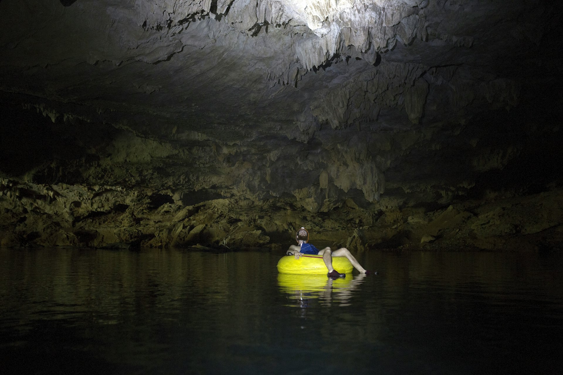 Man river tubing inside a cave in Belize.