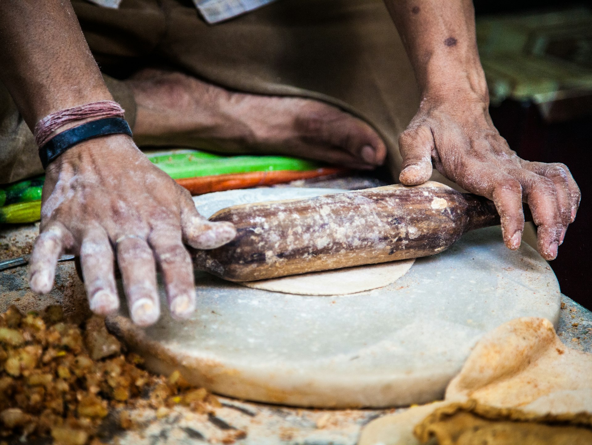 Indian man rolling dough for parathas on an Old Delhi street.