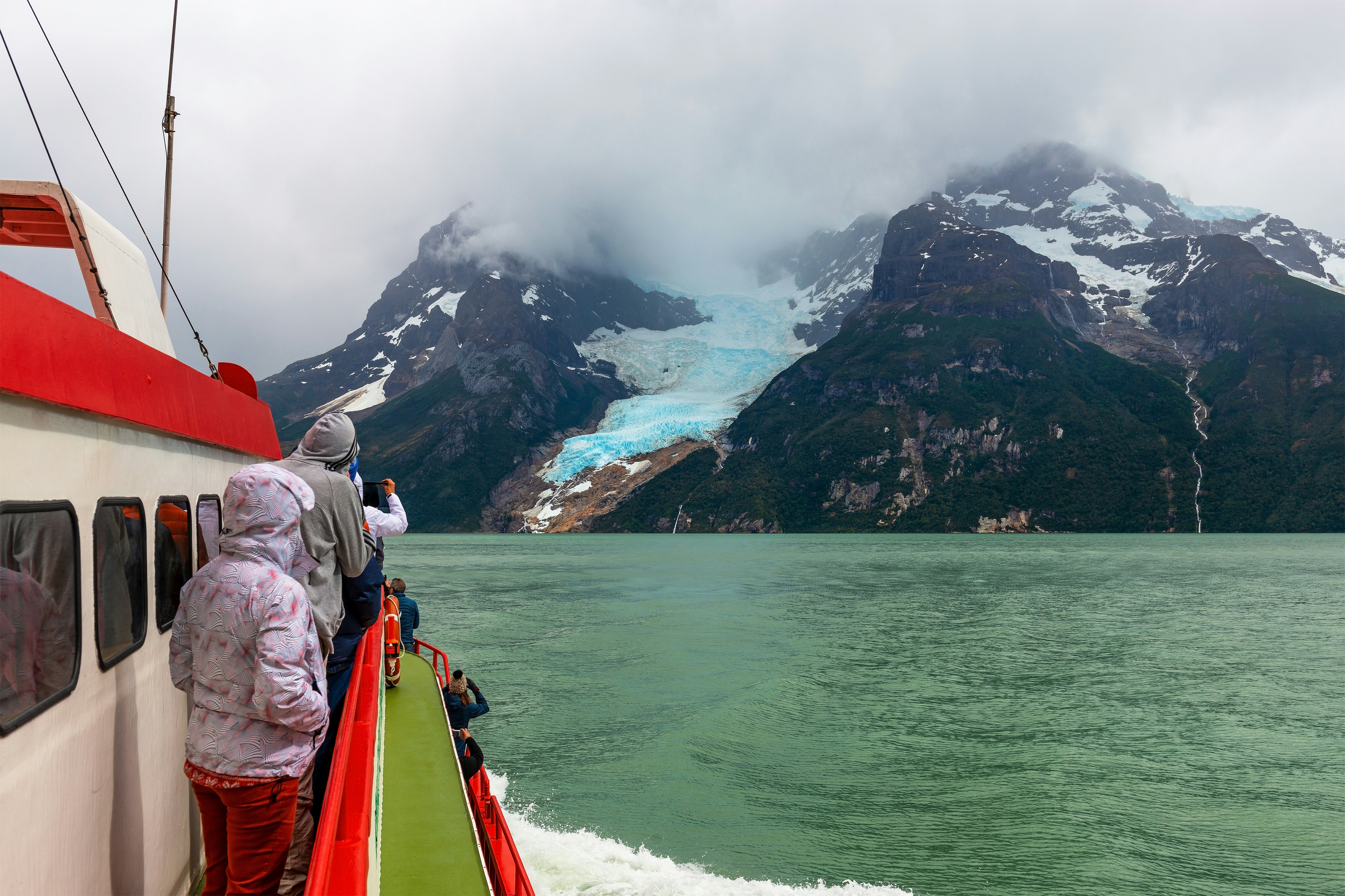 Tourists on a exploration cruise approaching the Balmaceda glacier on the Last Hope Sound, Bernardo O Higgins National Park, Patagonia, Chile.