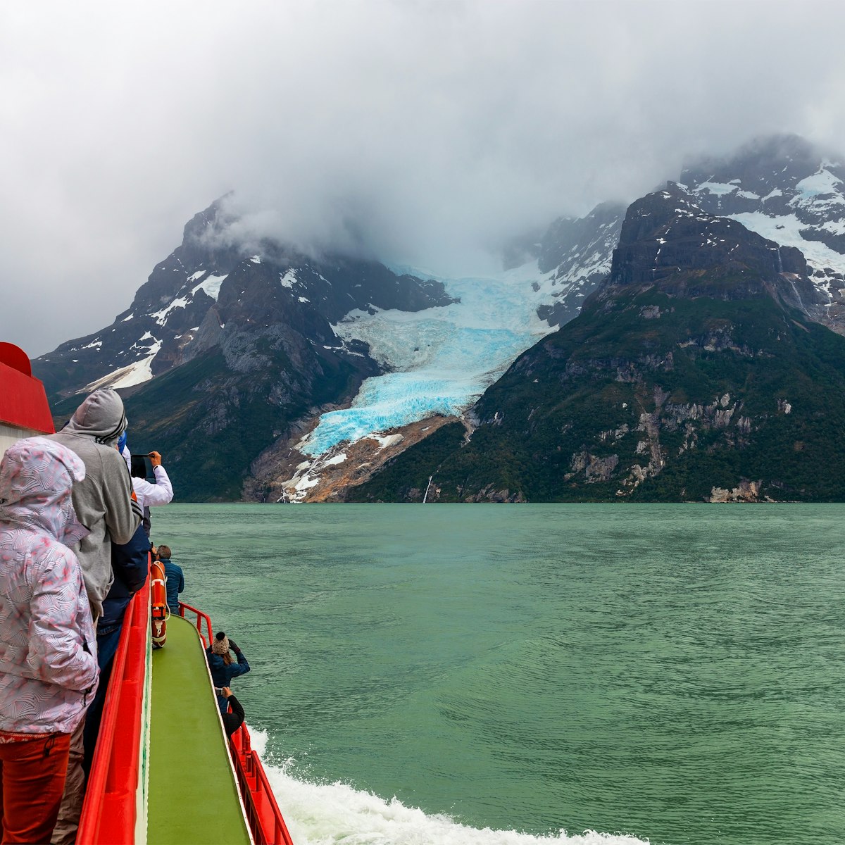 Tourists on a exploration cruise approaching the Balmaceda glacier on the Last Hope Sound, Bernardo O Higgins National Park, Patagonia, Chile.
