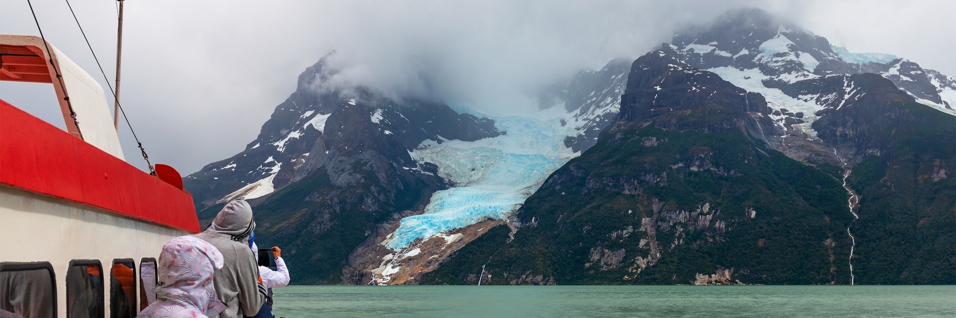 Tourists on a exploration cruise approaching the Balmaceda glacier on the Last Hope Sound, Bernardo O Higgins National Park, Patagonia, Chile.