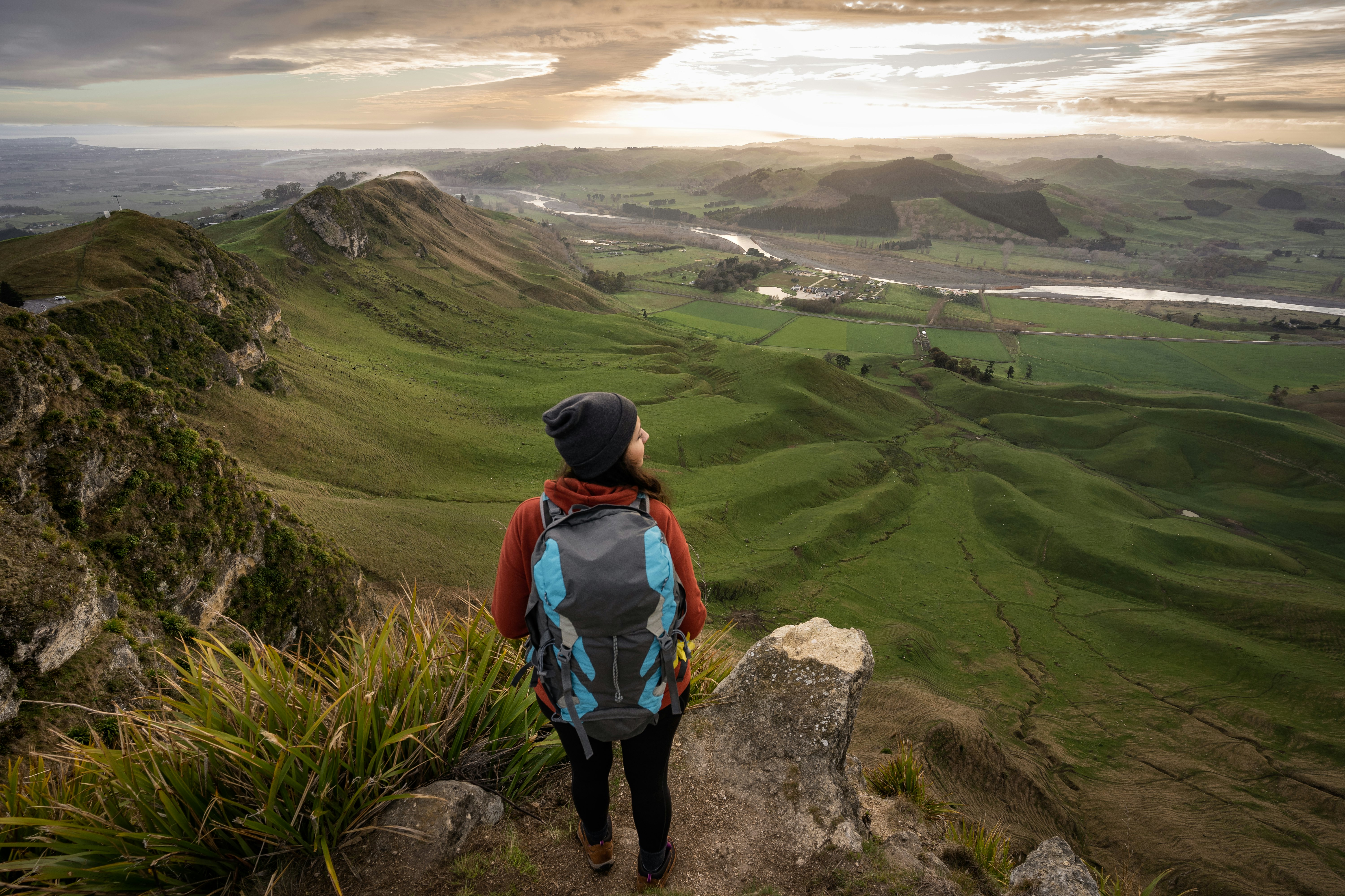 A backpacker standing at the top of Te Mata Peak in Hawke's Bay, New Zealand.