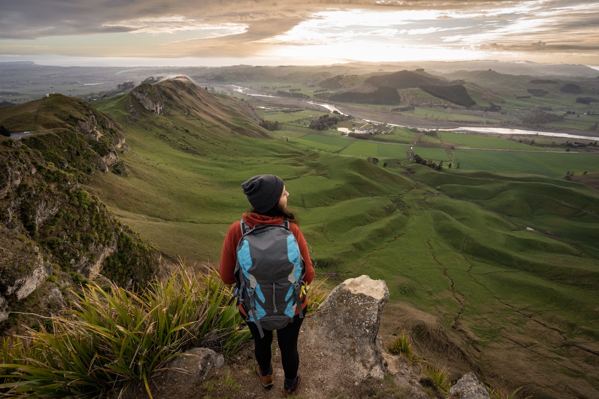 A backpacker standing at the top of Te Mata Peak in Hawke's Bay, New Zealand. 