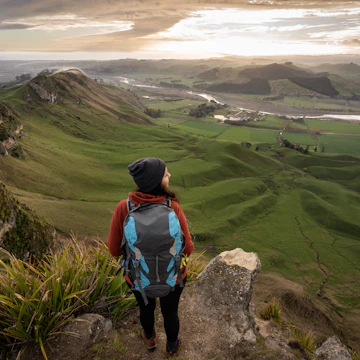 A backpacker standing at the top of Te Mata Peak in Hawke's Bay, New Zealand.