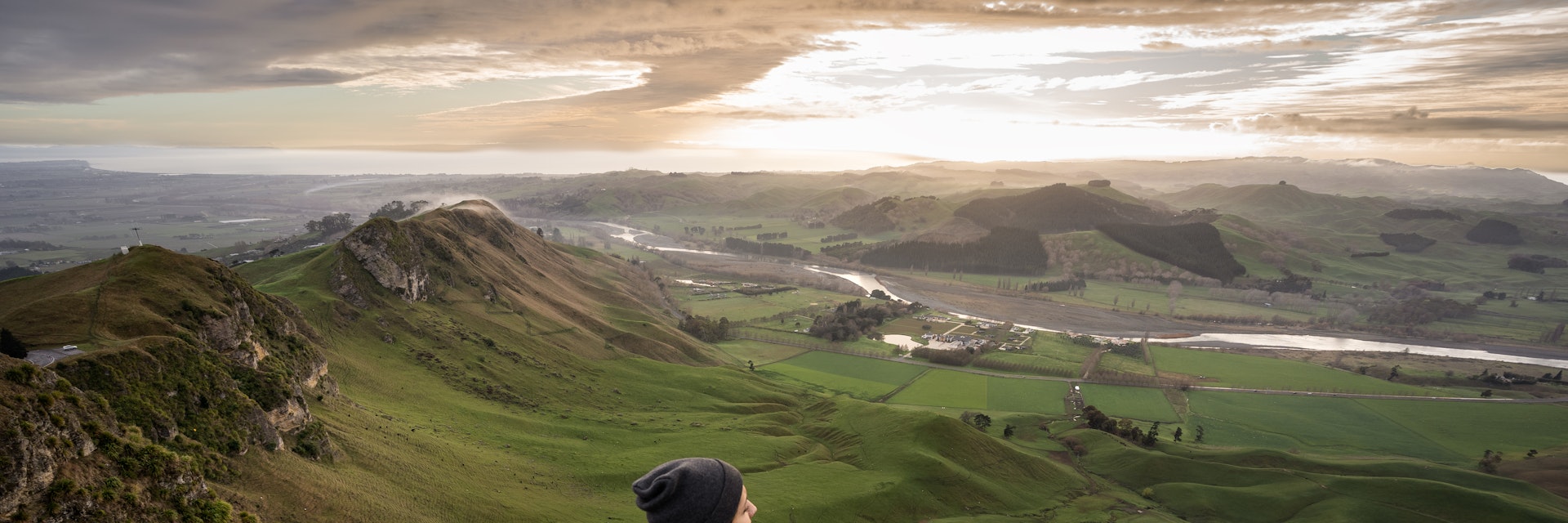A backpacker standing at the top of Te Mata Peak in Hawke's Bay, New Zealand.
