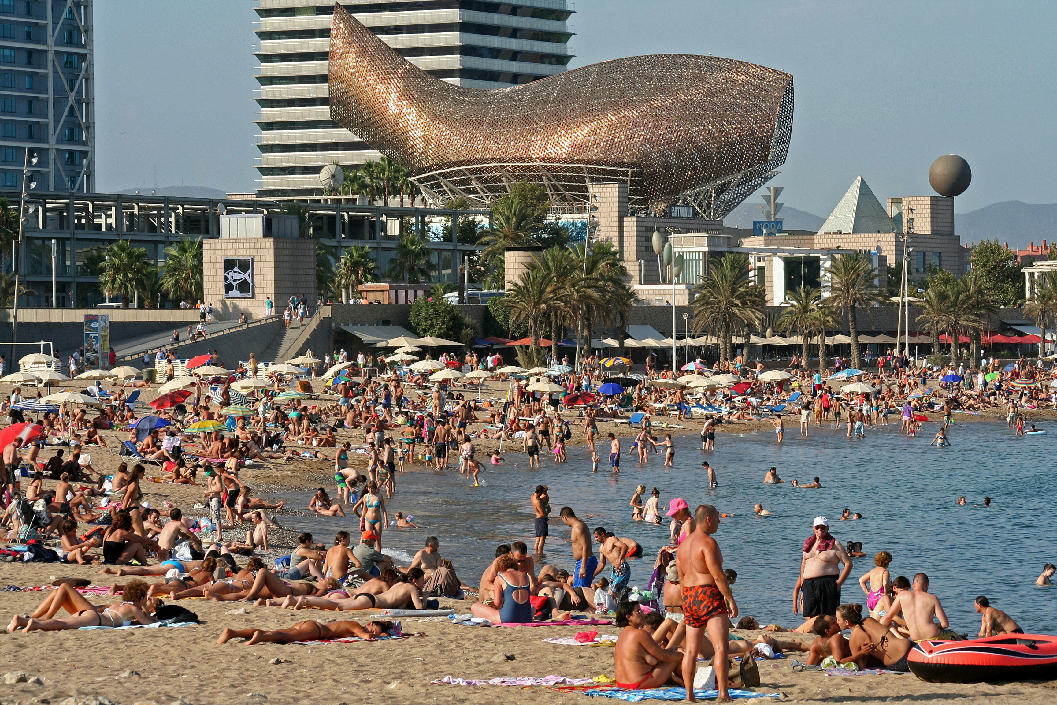 Barceloneta Beach with Frank Gehry's Peix d'Or (Whale Sculpture) on the beach of Barceloneta in Barcelona, Spain.