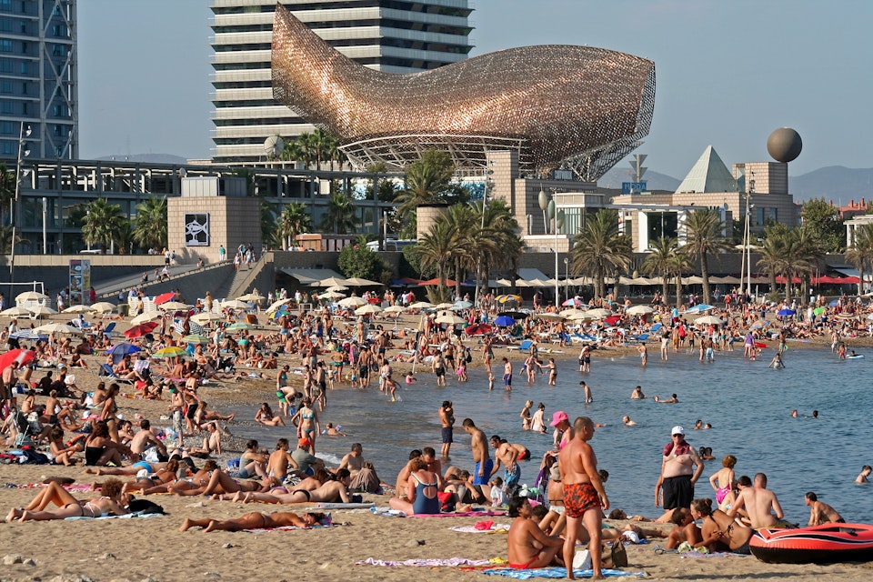 Barceloneta Beach with Frank Gehry's Peix d'Or (Whale Sculpture) on the beach of Barceloneta in Barcelona, Spain.