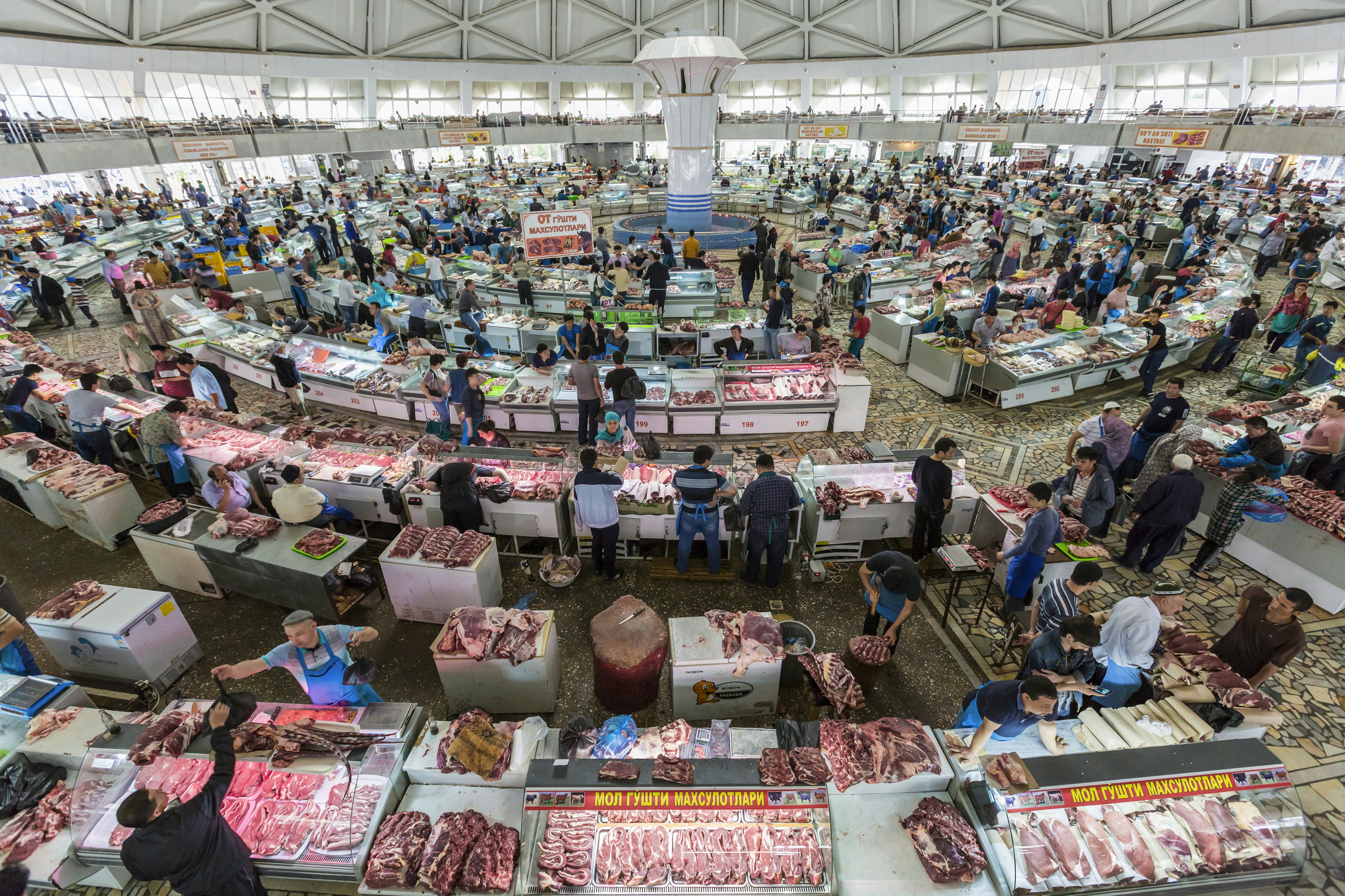 People shop in the meat section of the Chorsu Bazaar in Tashkent, Uzbekistan.