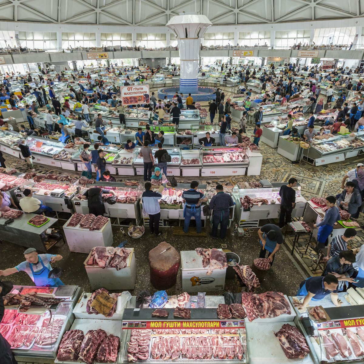 People shop in the meat section of the Chorsu Bazaar in Tashkent, Uzbekistan.