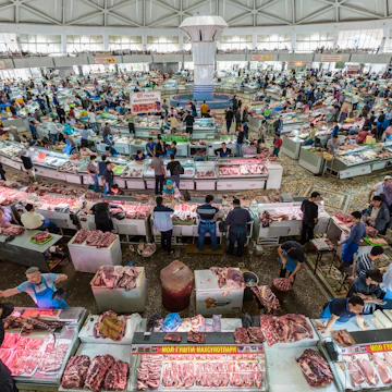 People shop in the meat section of the Chorsu Bazaar in Tashkent, Uzbekistan.
