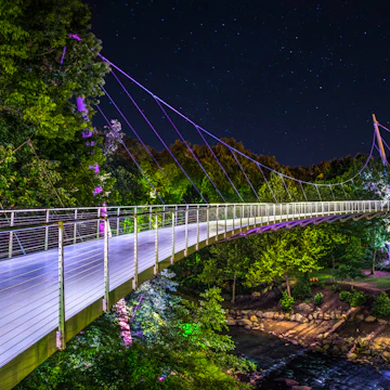 Illuminated Liberty Bridge in Falls Park downtown Greenville South Carolina on a starry night.