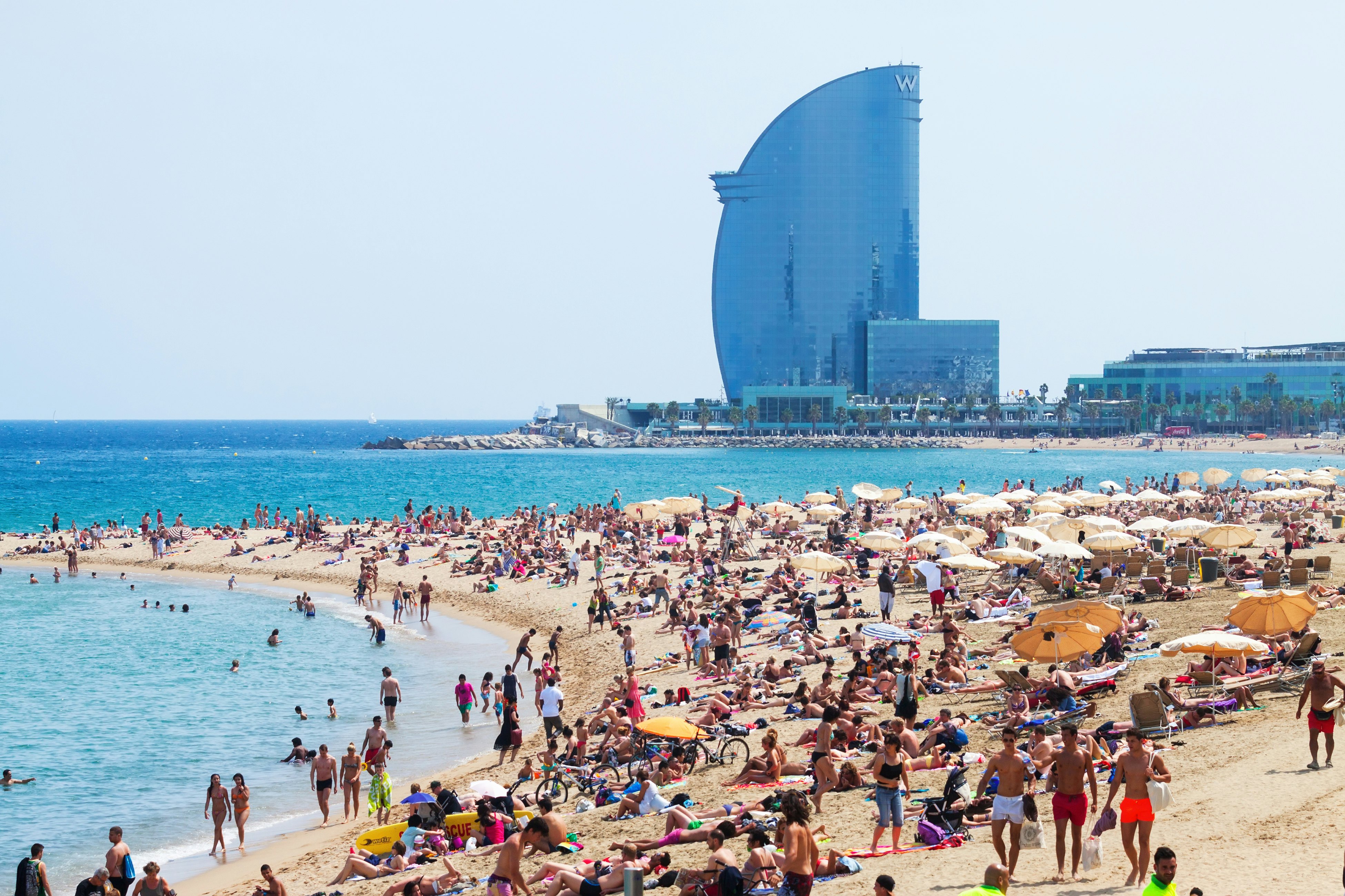 Barceloneta Beach against W Barcelona Hotel in Barcelona, Spain.  Barceloneta Beach - one of the most popular in the city. @BearFotos/Shutterstock