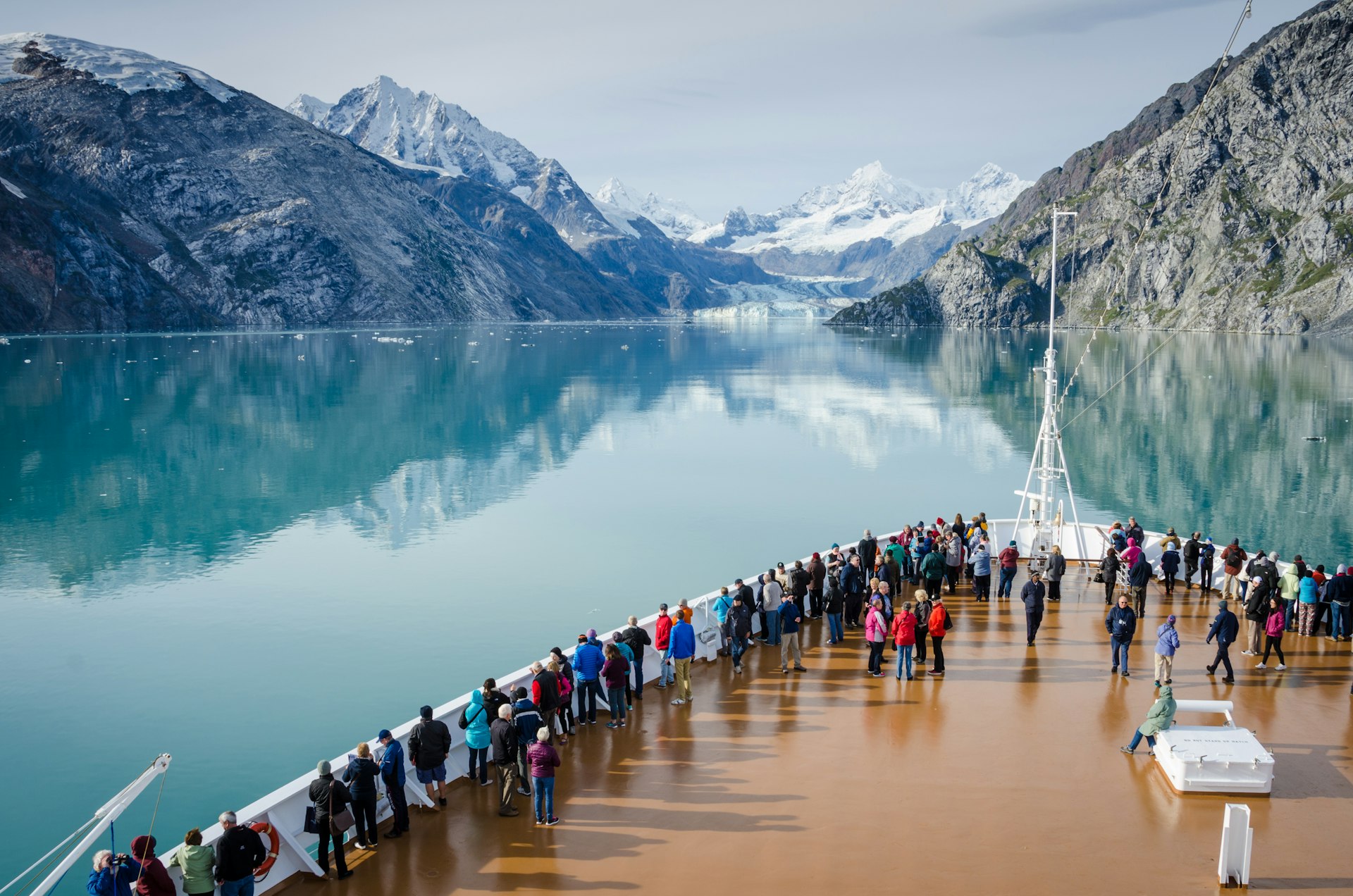 Cruise ship passengers stood on deck,  get a close-up view of the majestic glaciers, Alaska