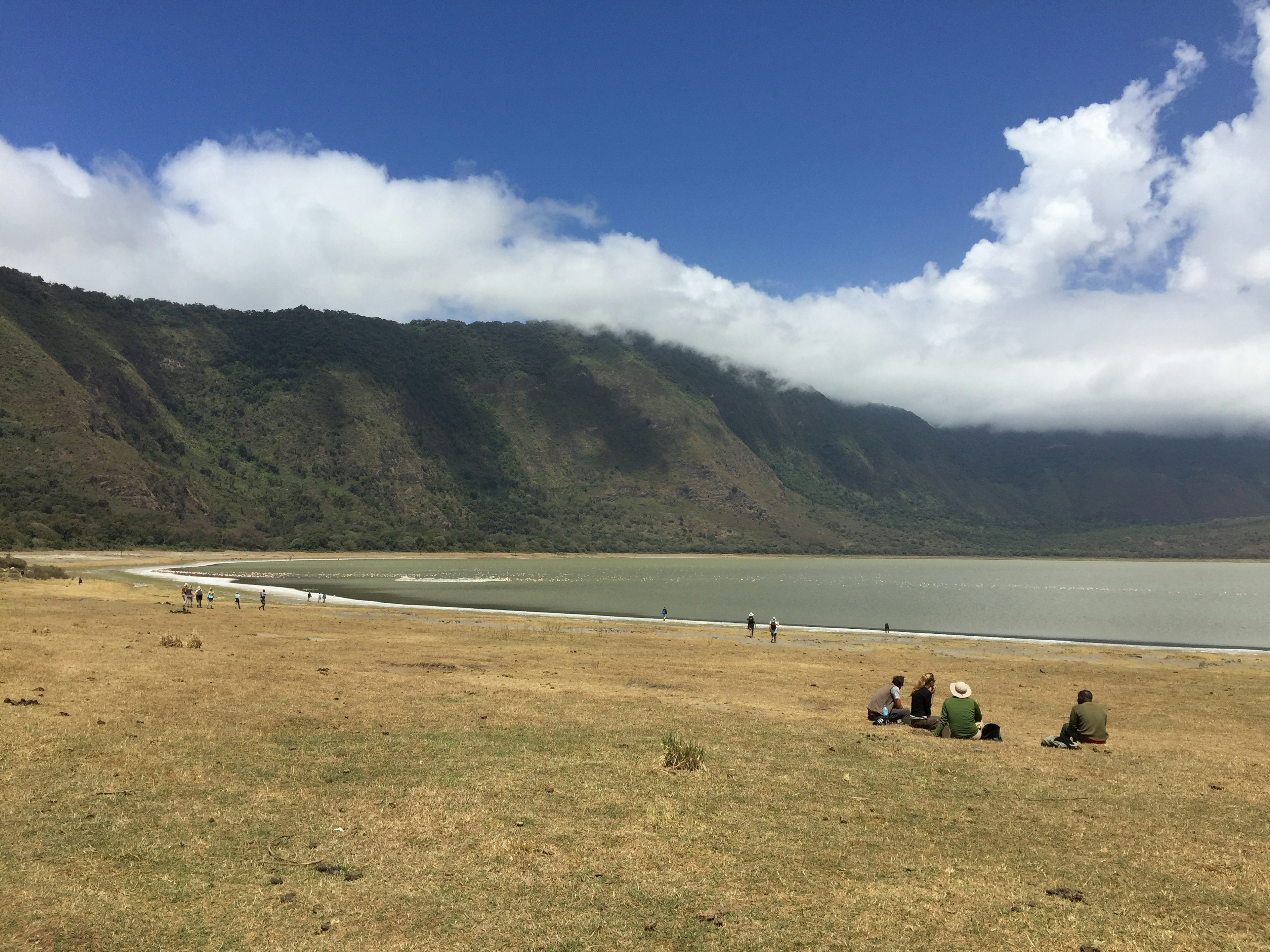 Visitors sat by water at the Empakaai Crater, Ngorongoro Conservation Area Tanzania,