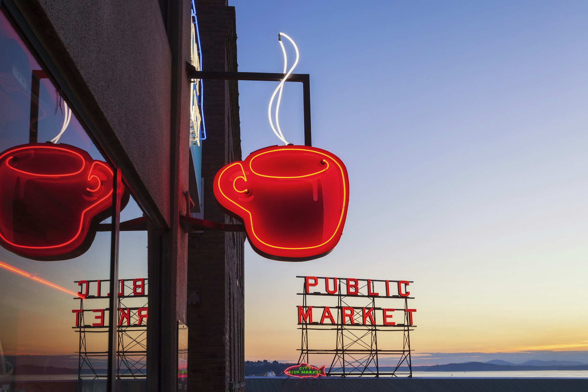 Neon Public Market sign with a steaming cup of coffee at Pike Place Market.