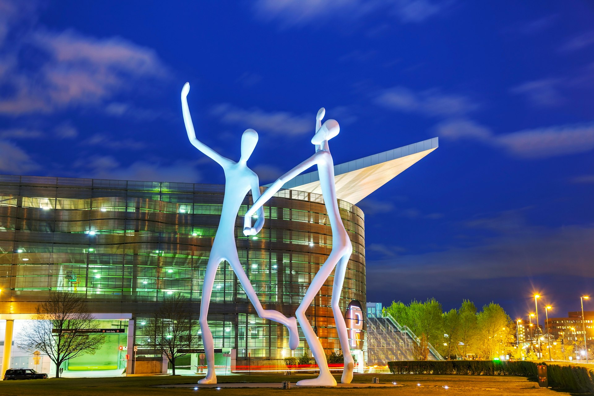The Dancers public sculpture at night, in front of the Denver Performing Arts Complex.