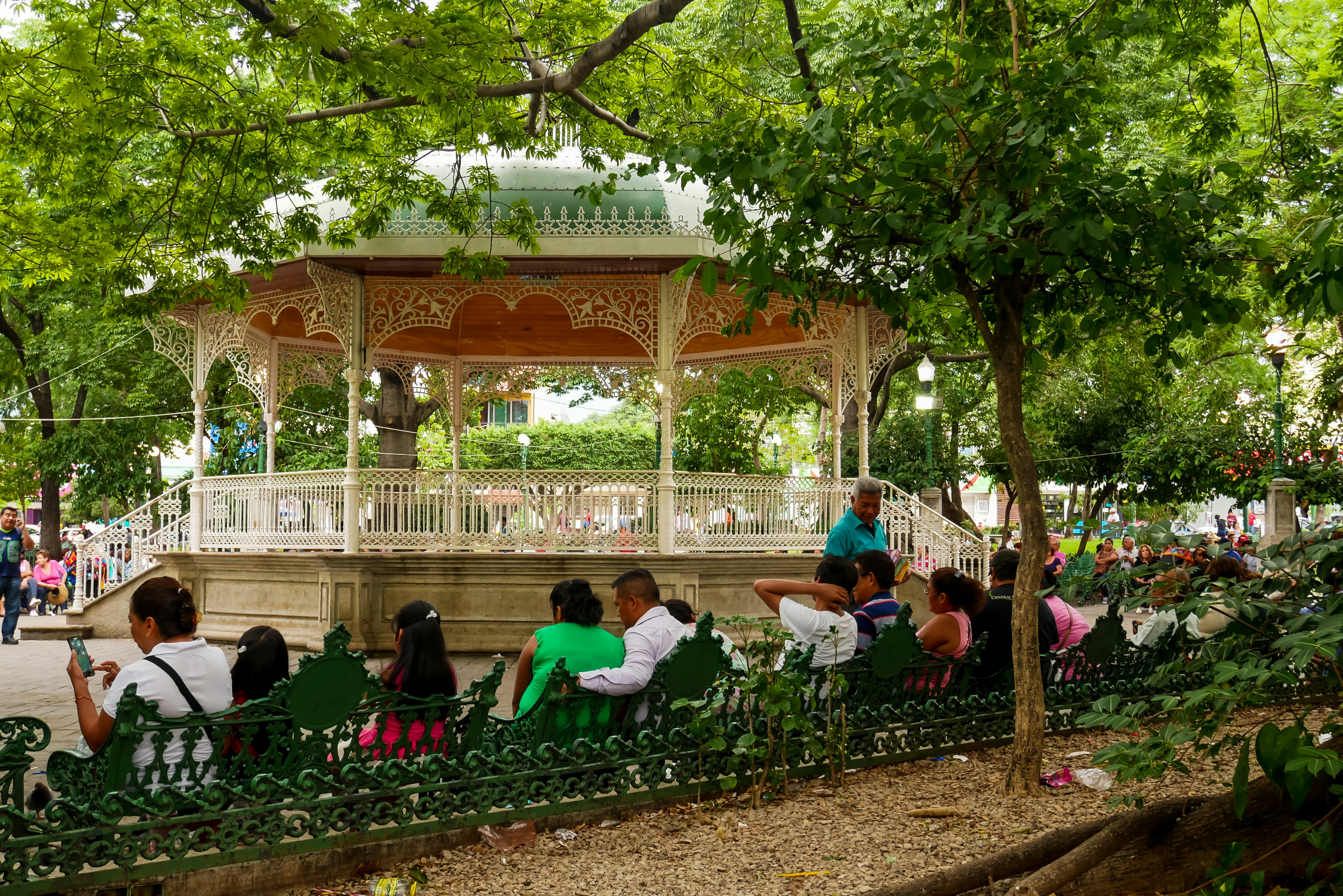 Locals relaxing on Marimba Park's benches in front of the picturesque bandstand in Tuxtla Gutiérrez, Mexico.