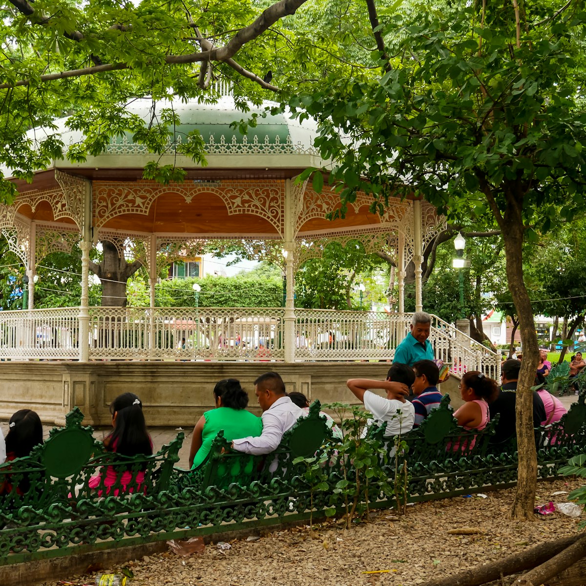 Locals relaxing on Marimba Park's benches in front of the picturesque bandstand in Tuxtla Gutiérrez, Mexico.