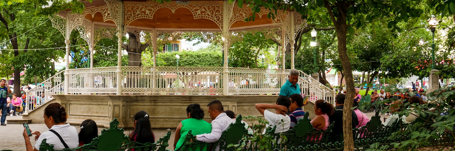 Locals relaxing on Marimba Park's benches in front of the picturesque bandstand in Tuxtla Gutiérrez, Mexico.