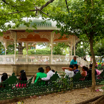 Locals relaxing on Marimba Park's benches in front of the picturesque bandstand in Tuxtla Gutiérrez, Mexico.
