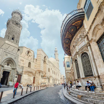 The minaret of Qalawun complex rises over Al-Muizz street.