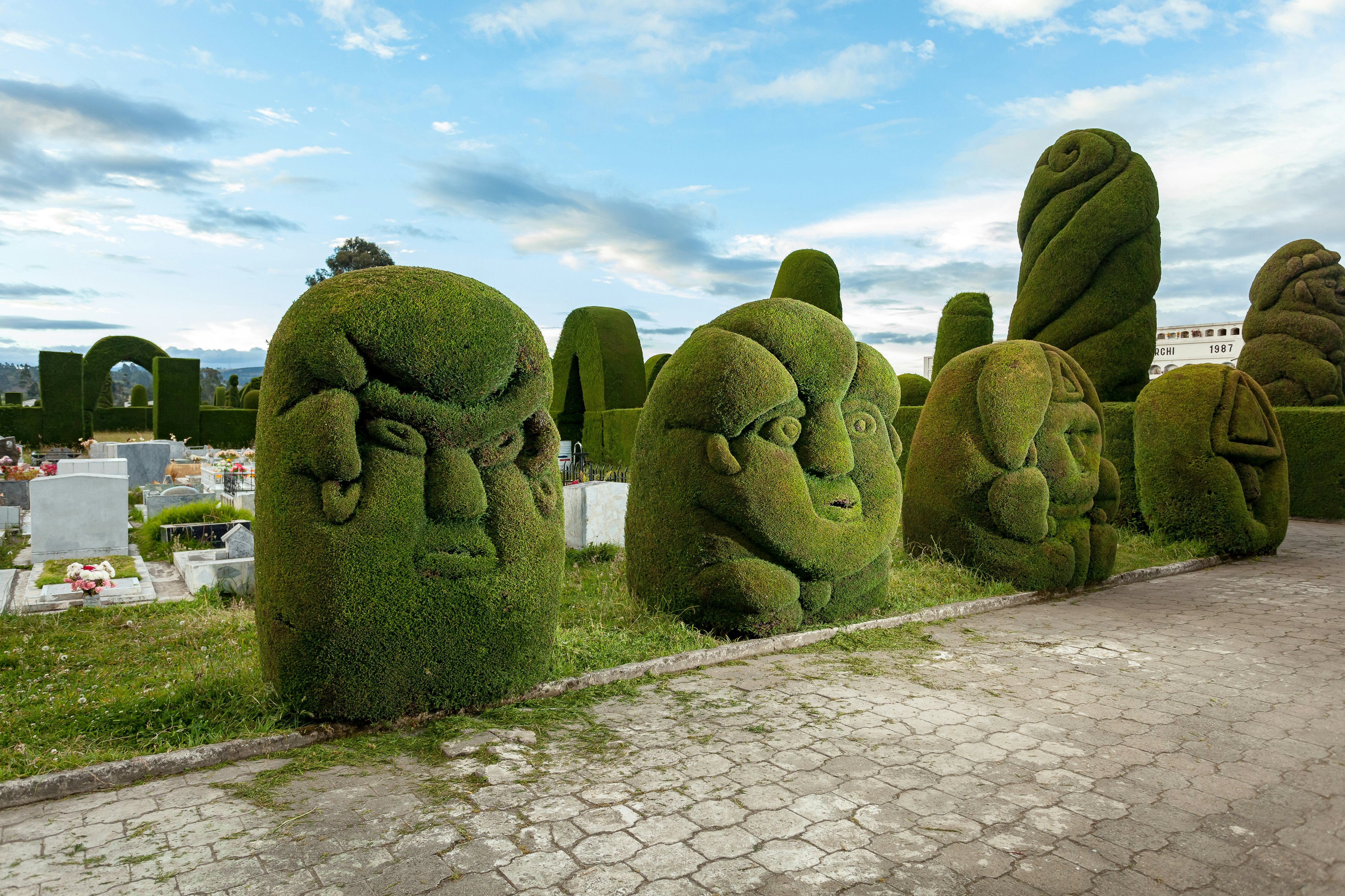 Green sculptures, carved in cypress bushes, adorn the corridors of the Tulcán Cemetery.