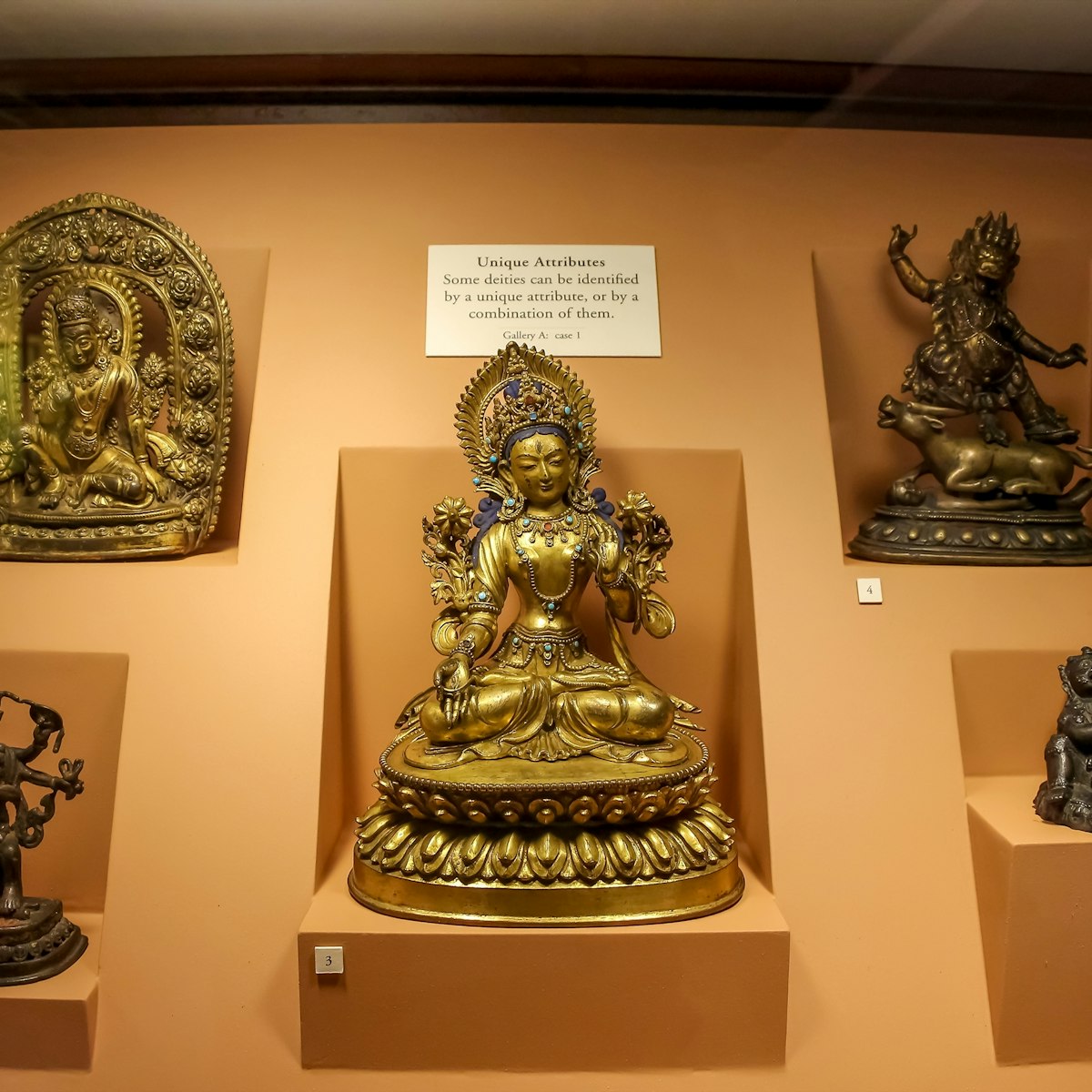 Group of bronze Buddha and Hindu Gods figurines in a showcase of the Patan Museum.