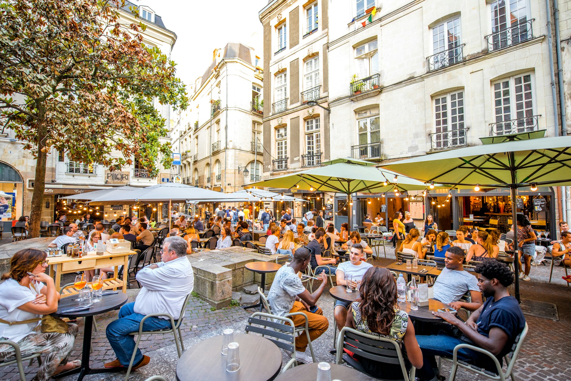 : Street view with cafes and restaurant full of people in the old town of Nantes city in France