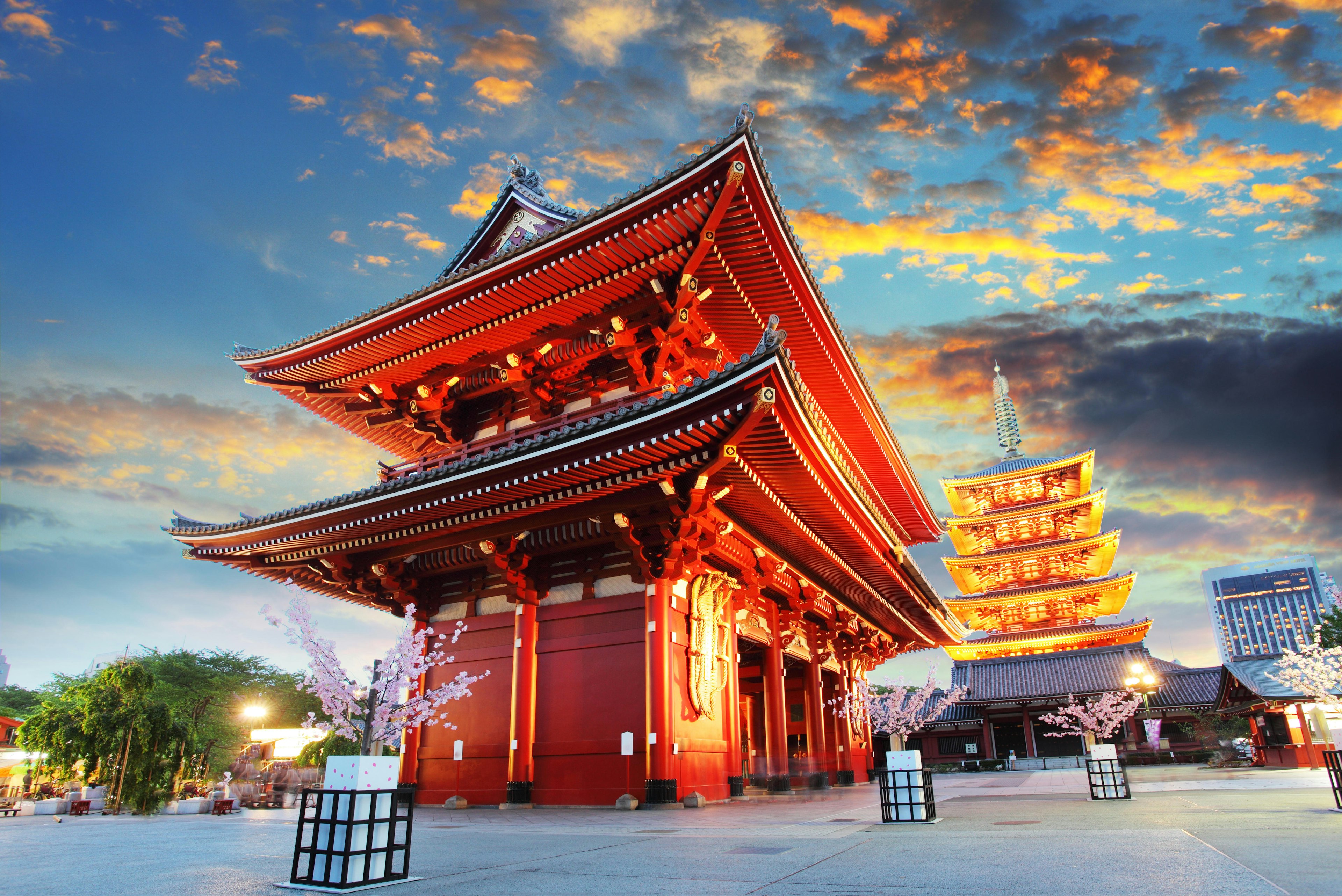 The red exterior of a Buddhist temple lit up at dusk