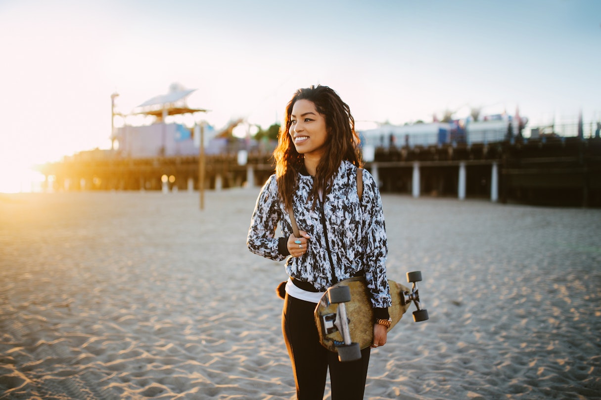 Young mixed Latina woman enjoying the beautiful Santa Monica beach in Los Angeles, California. She is wearing a fashionable spring jacket, going to meet her friends near the beach, holding an old school longboard under her arm.
1133479582
relaxation, only women, one person, beautiful woman, enjoyment, satisfaction, long hair, beauty, 25-29 years, women, horizontal, summer, curly hair, jacket, portrait, city life, fashion, side view, california, lifestyles, outdoors, young women, beautiful people, santa monica, latin american and hispanic ethnicity, venice beach, happiness, fashionable, city of los angeles, latin american culture, cool attitude, walking, mixed race person, los angeles county, real people, candid, street style, retro style, skateboard, tan, surfing, skateboarding, longboard skating, hipster - person, sunset, back lit, beach, pier, toothy smile