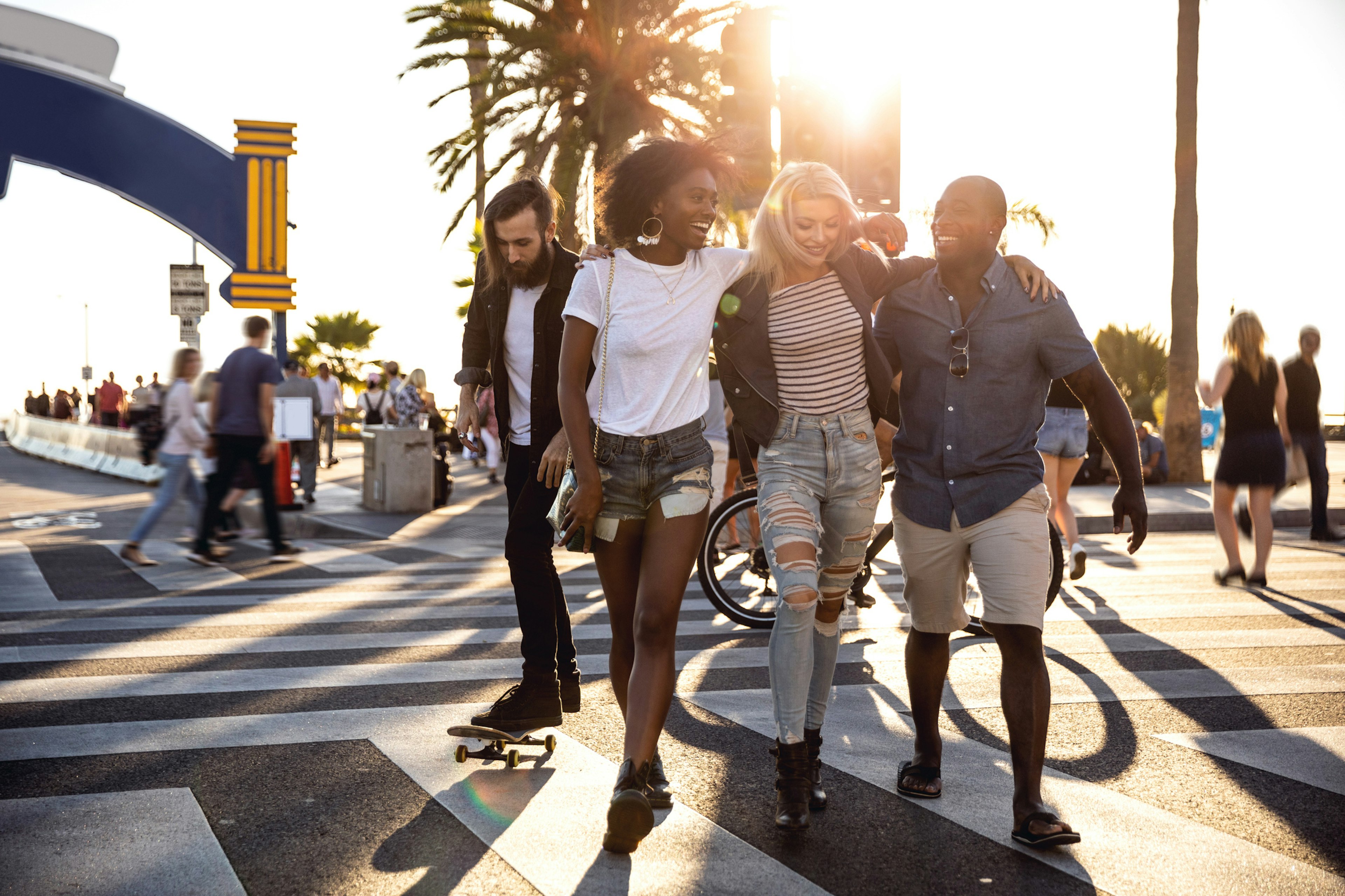 A group of friends laughing as they walk along a street in Santa Monica