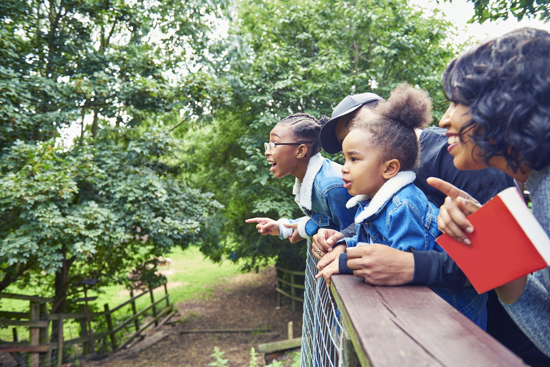 Young kids and their parents looking out at a park in London from a platform