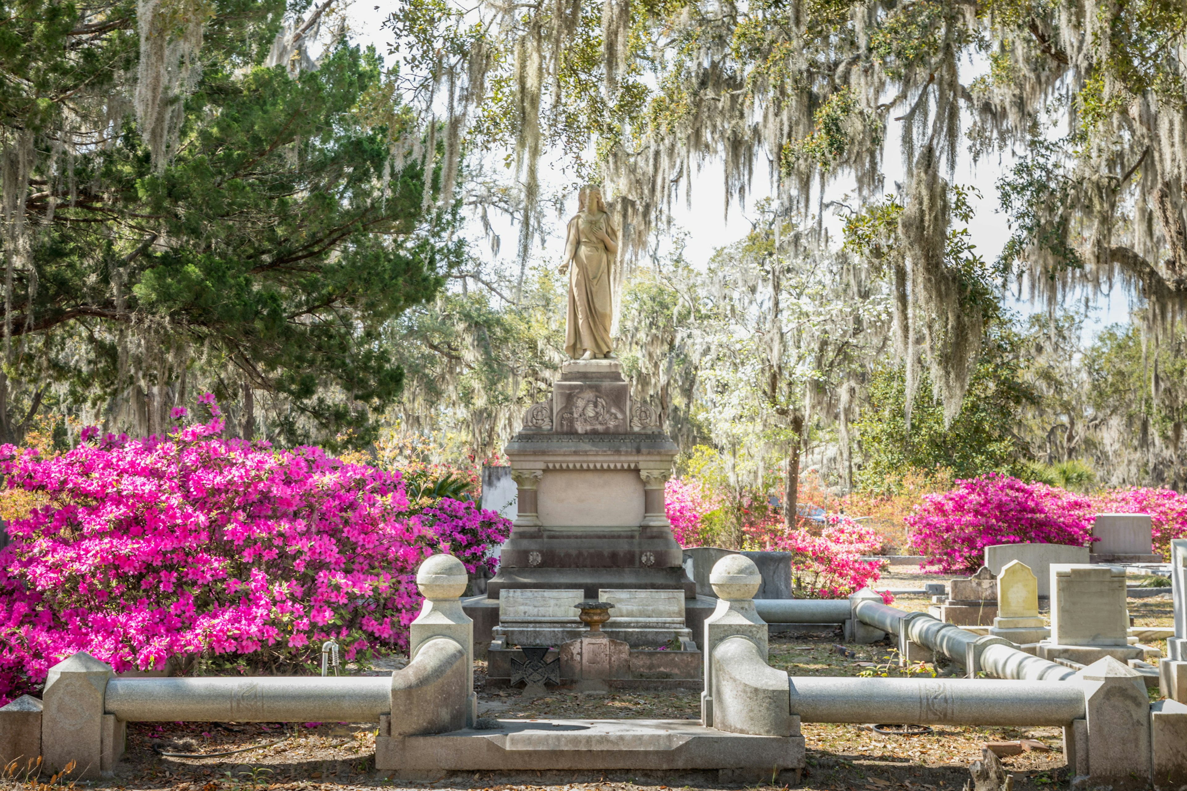 A large sculpture stands tall in the center of a mausoleum surrounded by Spanish oak that droops low from the trees