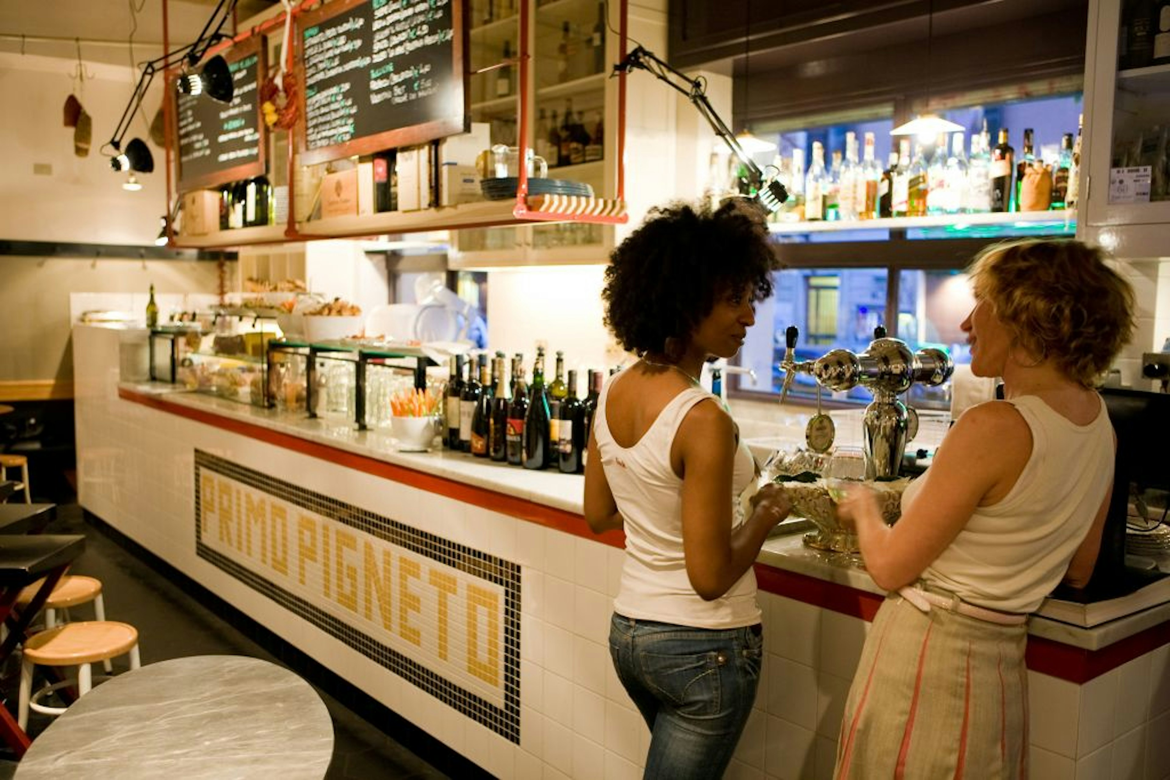 Two woman stand next to the beer tap at Ristorante Primo al Pigneto in Rome